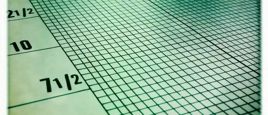 A close view of green squared paper with printed scale numbers along its left edge